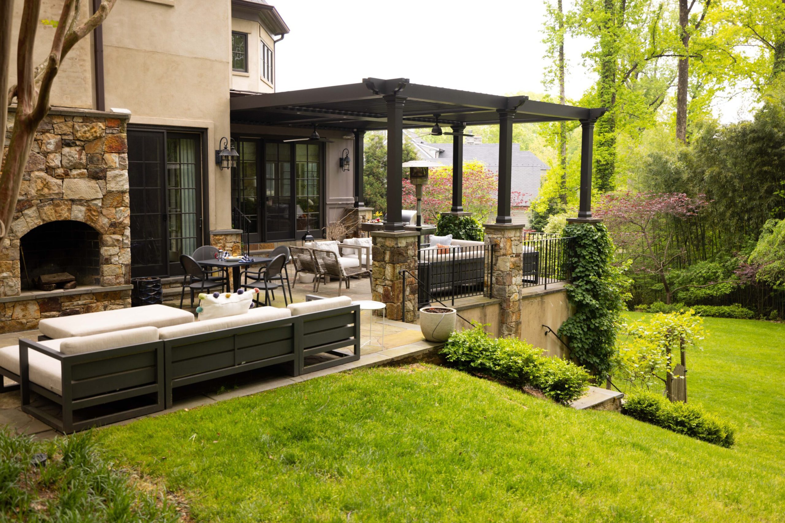 A landscaped residential yard with planting, lawn and an outdoor living area